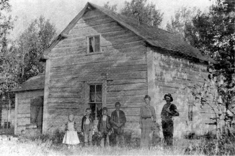 People standing in front of a wood house