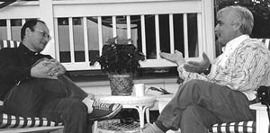 Earl Schwartz and David Hawkinson seated on a porch, talking